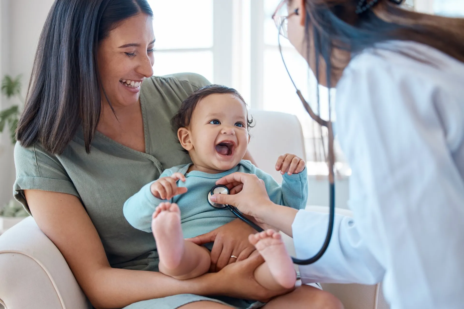 Mãe com bebê no colo durante consulta com médica pediatra